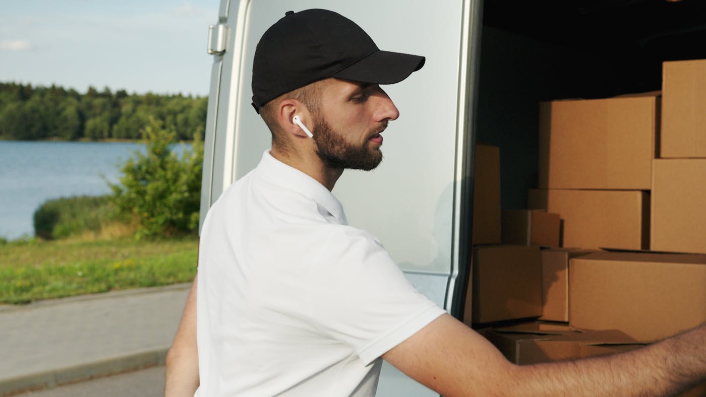 Delivery team member preparing parcels beside a van